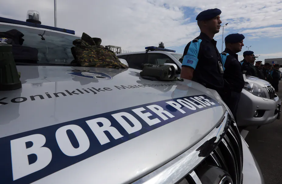 Frontex police man standing beside border police car